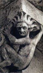 La sculpture image un personnage nu et les cheveux dressés sur l'un des modillons extérieurs dans la cathédrale Saint-Etienne à Cahors dans le Lot (France).  JPEG - 11.3 ko