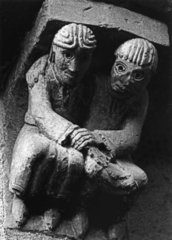 Sculpture en pierre représentant un couple assis, les mains réunies, sur le modillon extérieur de l'église Saint-Hilarion à Espalion en Aveyron (France).  JPEG - 10.3 ko
