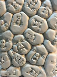 sculpture de visages de nourrissons agglutinés.  JPEG - 30.6 ko
