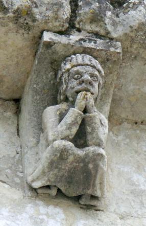 Modillon figurant un personnage confus à l'église de Corme-Ecluse en Charente-Maritime (France).  JPEG - 30.8 ko