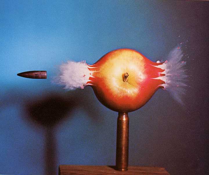 Photo à déclenchement très rapide d'une balle de fusil traversant une pomme.  JPEG - 27.9 ko