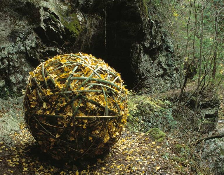 La plus grande des sphères de Chris Drury, près de la rivière de Shimanto, est composée de feuilles de gingko encerclées par un tressage de lanières d'ecorce.  JPEG - 168.7 ko